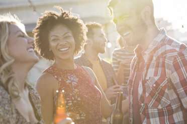 Freunde feiern eine Dachterrassenparty, unterhalten sich und trinken Bier - WESTF22884