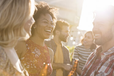 Freunde feiern eine Dachterrassenparty, unterhalten sich und trinken Bier - WESTF22885