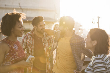 Freunde feiern eine Dachterrassenparty, unterhalten sich und trinken Bier - WESTF22886