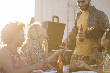 Freunde feiern eine Dachterrassenparty, unterhalten sich und trinken Bier - WESTF22887