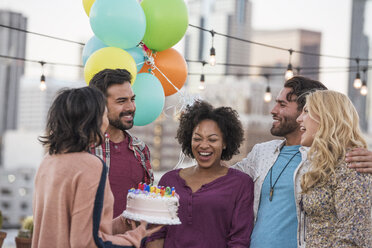 Freunde feiern Geburtstagsparty auf der Dachterrasse mit Geburtstagstorte - WESTF22896