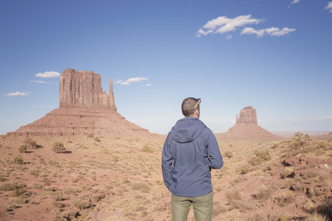 USA, Utah, Rückenansicht eines Mannes mit Blick auf das Monument Valley, lizenzfreies Stockfoto
