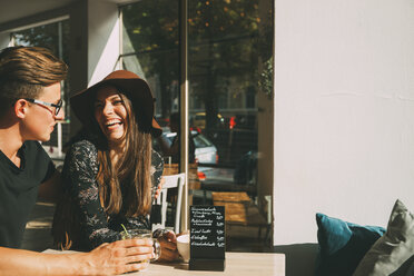 Couple sitting in a coffee shop having fun - CHAF01823