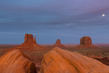 USA, Colorado Plateau, Utah, Arizona, Navajo Nation Reservation, Monument Valley, West Mitten Butte, East Mitten Butte and Merrick Butte at dawn with full moon - FOF09152