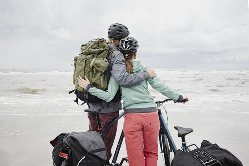 Germany, Schleswig-Holstein, St Peter-Ording, couple with bicycles on the beach - RORF00711