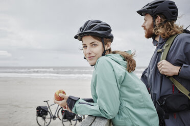 Deutschland, Schleswig-Holstein, St. Peter-Ording, Pärchen auf Fahrradtour mit Pause auf Steg am Strand - RORF00724