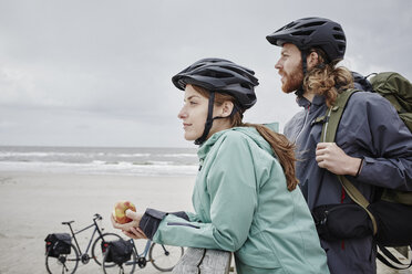 Deutschland, Schleswig-Holstein, St. Peter-Ording, Pärchen auf Fahrradtour mit Pause auf Steg am Strand - RORF00725