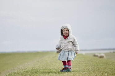 Germany, Schleswig-Holstein, Eiderstedt, happy little girl standing on dyke - RORF00742