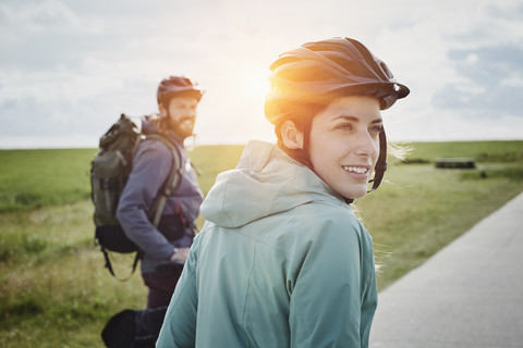 Deutschland, Schleswig-Holstein, Eiderstedt, Pärchen auf Fahrradtour macht Pause in Marschlandschaft, lizenzfreies Stockfoto