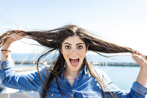 Portrait of screaming young woman pulling her hair stock photo