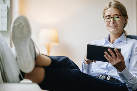 Geschäftsfrau im Sitzen mit Tablet, lizenzfreies Stockfoto