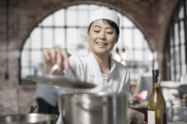 Lächelnde Köchin beim Kochen in der Küche - ZEF13488