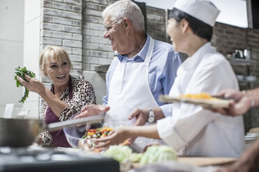 Glückliches älteres Ehepaar und Köchin beim Kochen im Kochkurs - ZEF13525