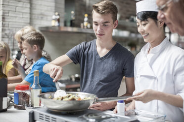 Teenager und Köchin kochen zusammen - ZEF13547