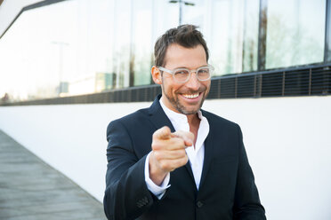 Portrait of confident businessman outdoors pointing his finger - CHAF01860