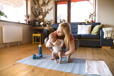 Mother with baby and dumbbells at home - HAPF01369