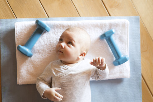 Baby zu Hause auf Matte neben Hanteln liegend - HAPF01374