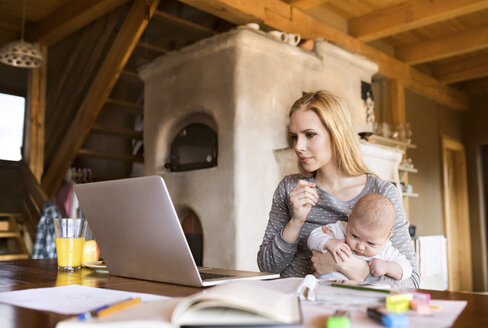 Mutter mit Baby zu Hause am Laptop - HAPF01382