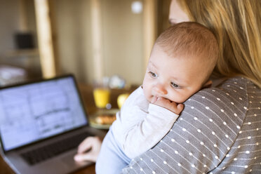 Mother with baby at home using laptop - HAPF01394