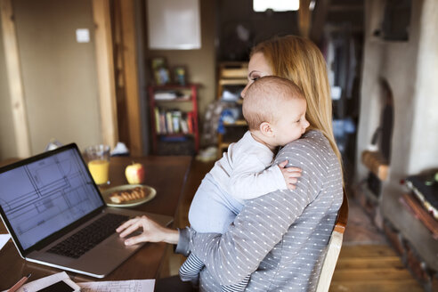 Mother with baby at home using laptop - HAPF01395