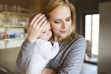 Smiling mother holding baby at home - HAPF01400