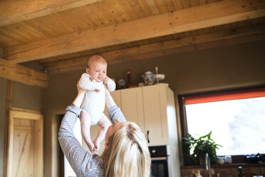 Mother lifting up baby at home - HAPF01401