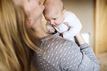 Happy mother holding baby at home - HAPF01402