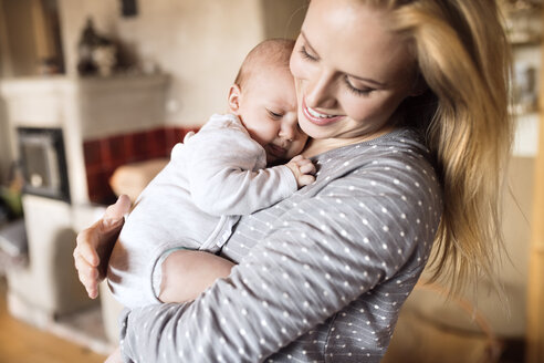 Glückliche Mutter hält ihr Baby zu Hause - HAPF01404