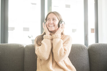 Glückliche junge Frau, die zu Hause Musik hört - SIPF01524