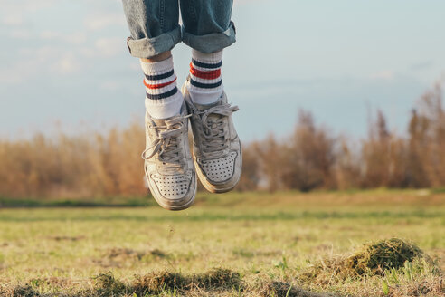 Shoes of man jumping on meadow - RTBF00799