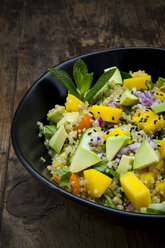 Bowl of quinoa salad with mango, avocado, tomatoes, cucumber, herbs and black sesame - LVF05985