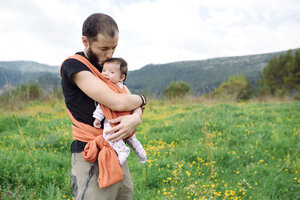 Vater trägt kleines Mädchen im Freien in einer Babytrage - GEMF01566