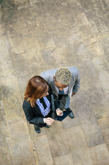 Junger Geschäftsmann und Frau schauen auf ein digitales Tablet - DAPF00644
