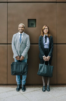 Junger Geschäftsmann und Frau stehen vor einer Stahlwand - DAPF00666