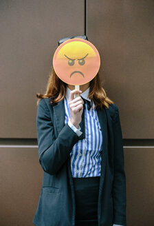 Frau versteckt Gesicht hinter Emoji-Maske - DAPF00671