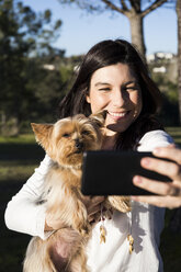 Glückliche junge Frau macht Selfie mit ihrem Hund - ABZF01944