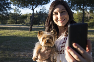 Glückliche junge Frau macht Selfie mit ihrem Hund - ABZF01947