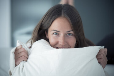 Portait of happy young woman lying on bed - SIPF01584