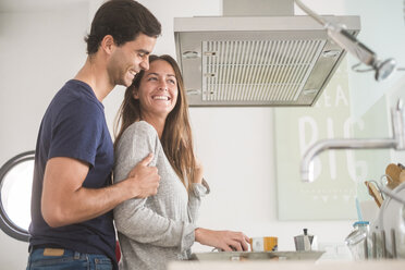 Happy young couple in love with coffee cups in kitchen - SIPF01601