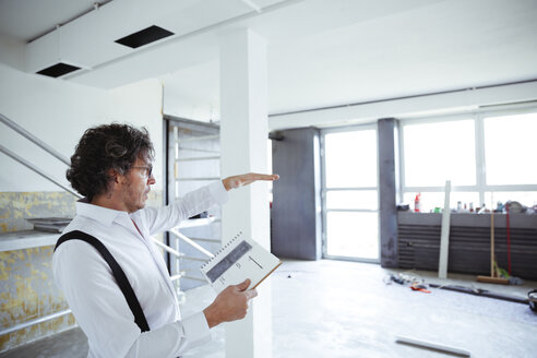 Architect with sketch book at construction site - REAF00246