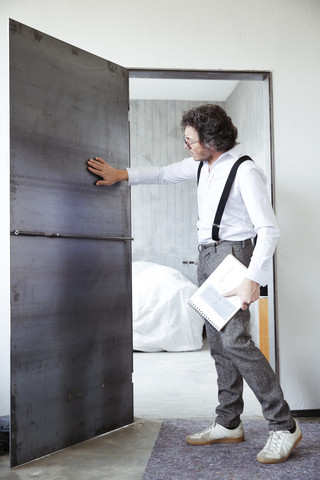 Architect checking steel door at construction site stock photo