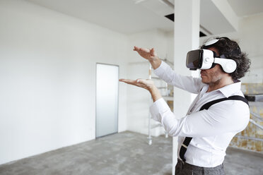Architekt mit Virtual-Reality-Brille auf der Baustelle - REAF00256