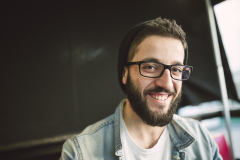 Porträt eines bärtigen jungen Mannes mit Brille und Hut, lizenzfreies Stockfoto