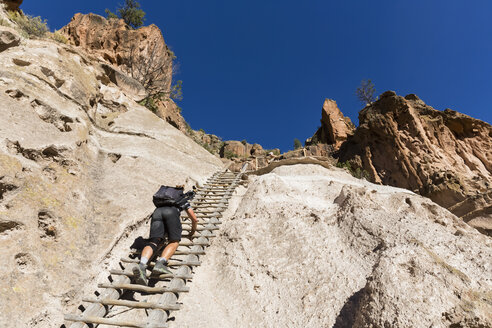 USA, New Mexico, Frijoles Canyon, Bandelier National Monument, Ruinen und rekonstruierte Kiva der Ancestral Pueblo People, Tourist auf Leiter zum Alcove House - FOF09168