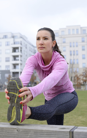 Weibliche Athletin beim Dehnen im Freien, lizenzfreies Stockfoto