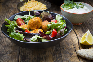 Bowl of mixed salad, tomatoes, sweet patato Falafel and Hummus, yoghurt sauce and flat bread - LVF06009