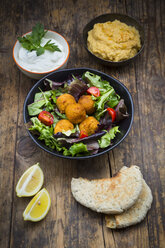 Bowls of mixed salad, tomatoes, sweet patato Falafel and Hummus, yoghurt sauce and flat bread - LVF06010