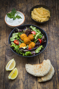Schüsseln mit gemischtem Salat, Tomaten, süßer Kartoffel Falafel und Hummus, Joghurtsauce und Fladenbrot - LVF06010