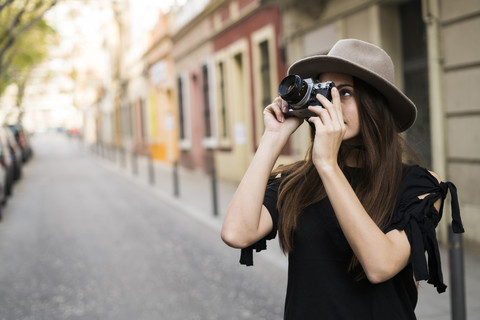 Junge Frau fotografiert mit Kamera im Freien, lizenzfreies Stockfoto