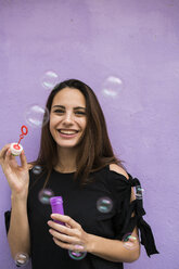 Portrait of smiling young woman with bubble ring - KKAF00647